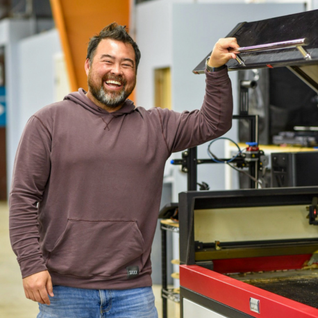 Cory smiling by the Boss laser